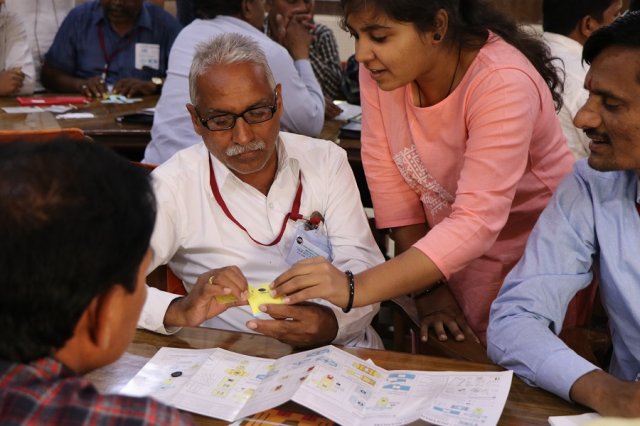 Resource person Manjusha explaining how to put the lens in the Foldscope.